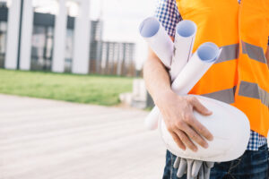 crop-man-with-blueprints-helmet